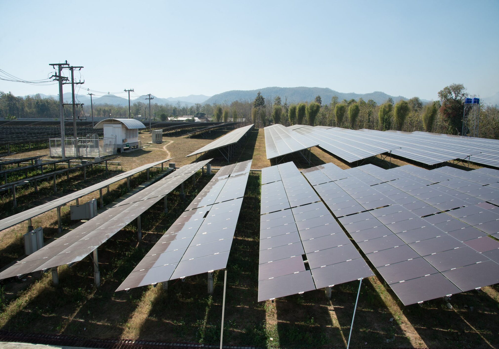 View of solar farm in sunlight with blue sky, dirty solar cell  array, green energy concept.